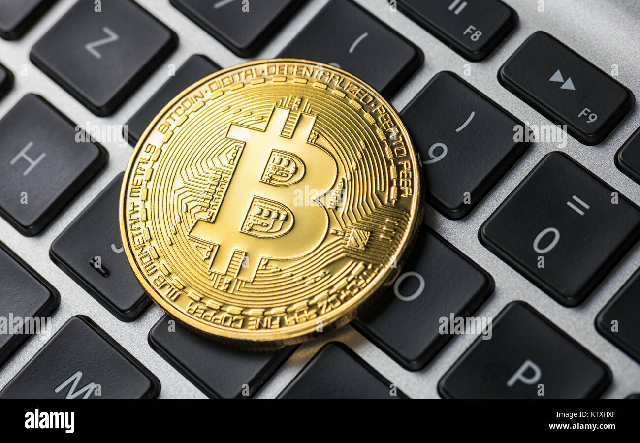 Golden Bitcoin on notebook Stock Photo