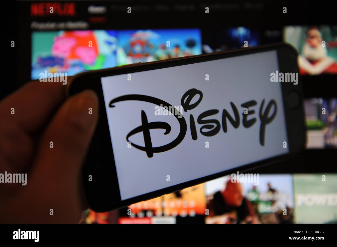 A Disney logo on a phone screen and Netflix on a computer screen Stock Photo