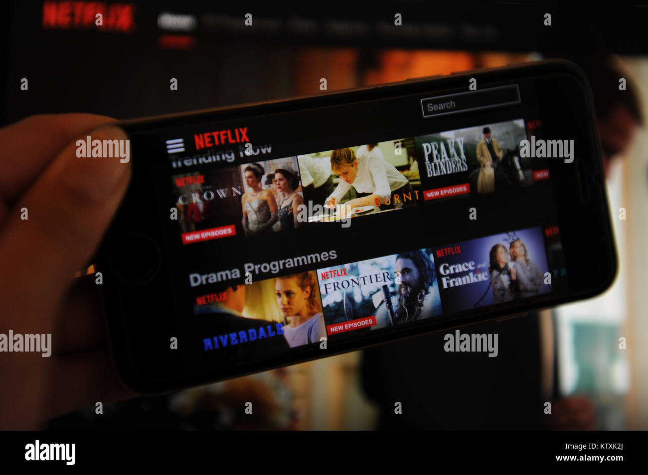 The Netflix website on a phone and computer screen Stock Photo