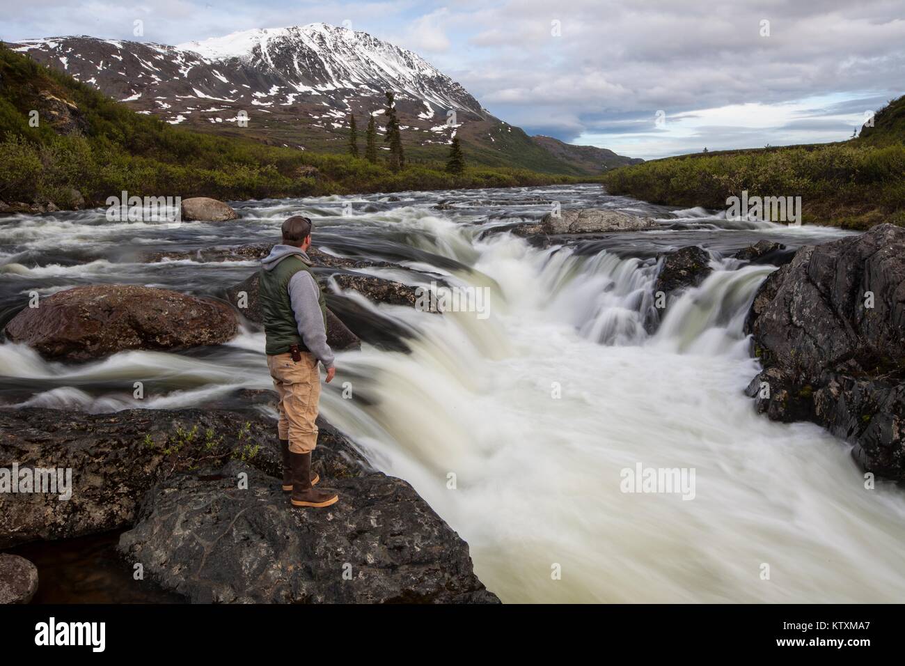 A hiker looks out on the Delta Wild and Scenic River June 19, 2014 in Alaska. Stock Photo