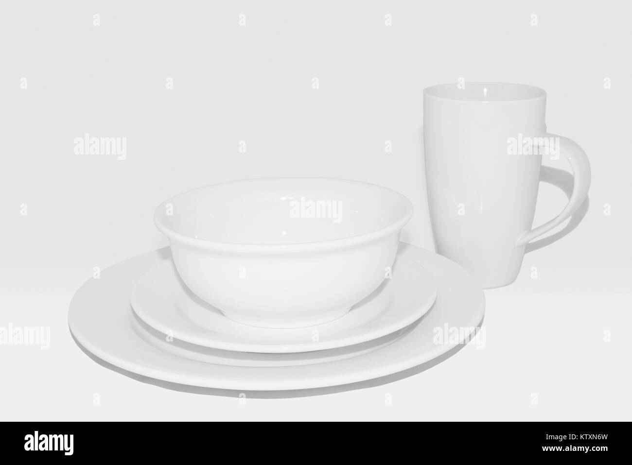 Crockery set including dinner plate, side plate, bowl and large white coffee mug/cup: White crockery against a white background,100% grayscale. Stock Photo