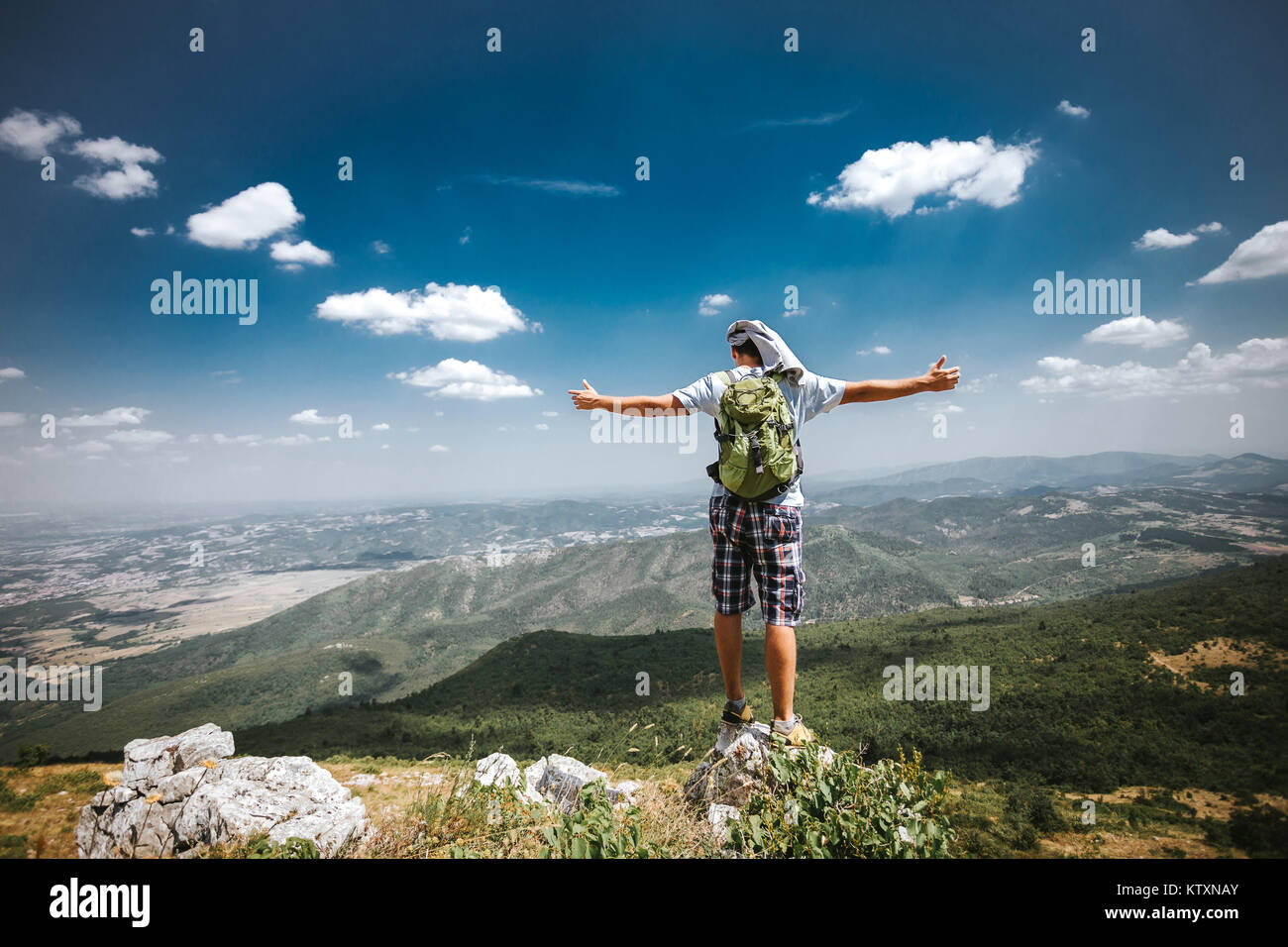 Male climb at the top of mountain, celebrating success. Stock Photo