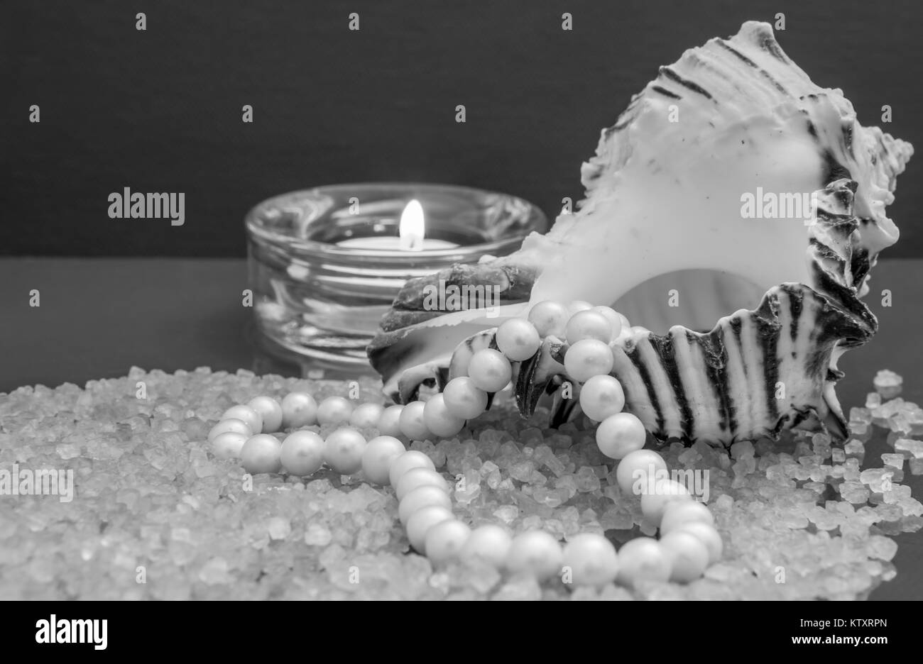 Bath accessories. Pearls inside the seashell over the sea salt in black and white Stock Photo