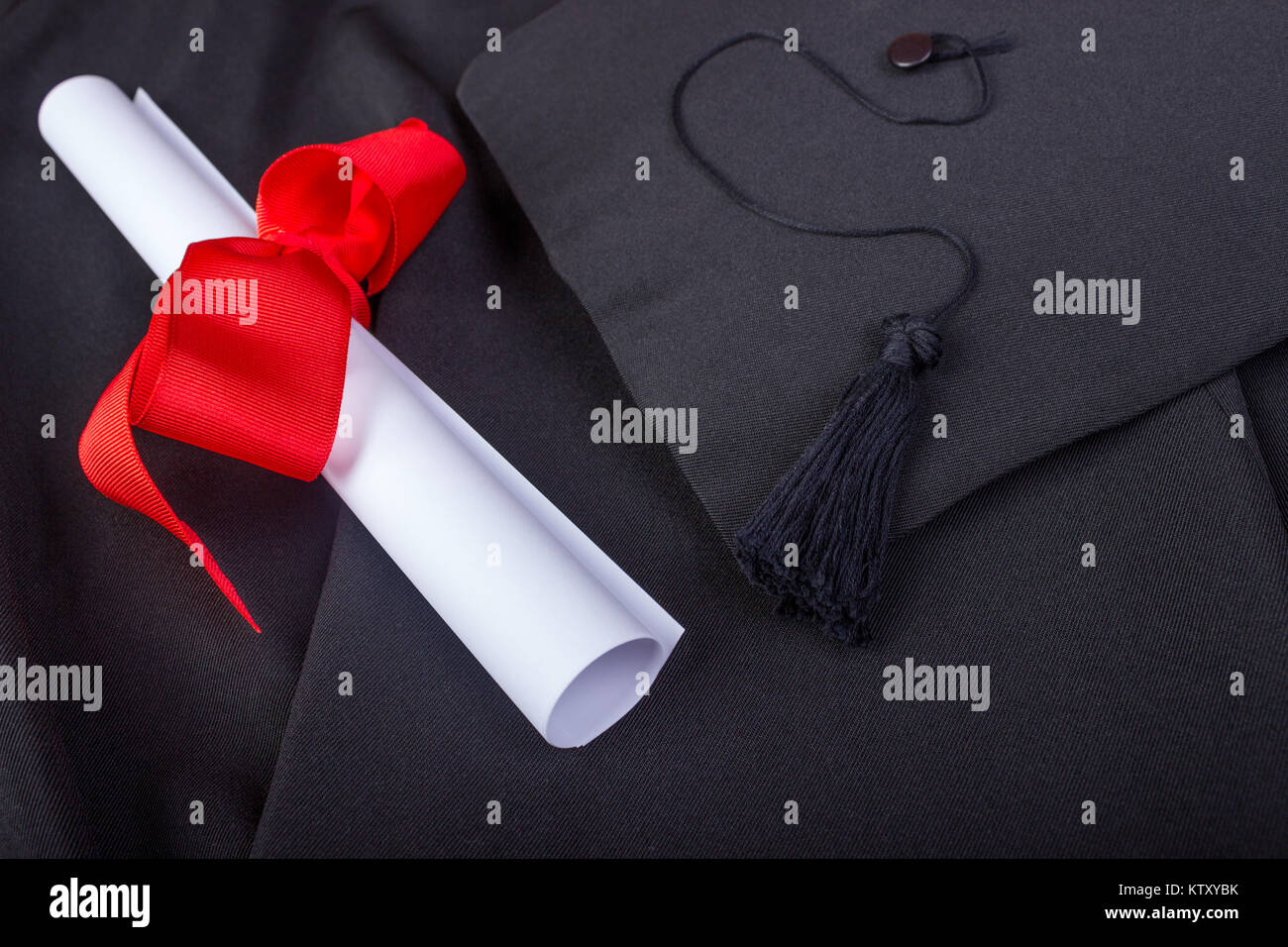 Graduation Day. A gown, graduation cap, and diploma and laid out ready for graduation day. Stock Photo