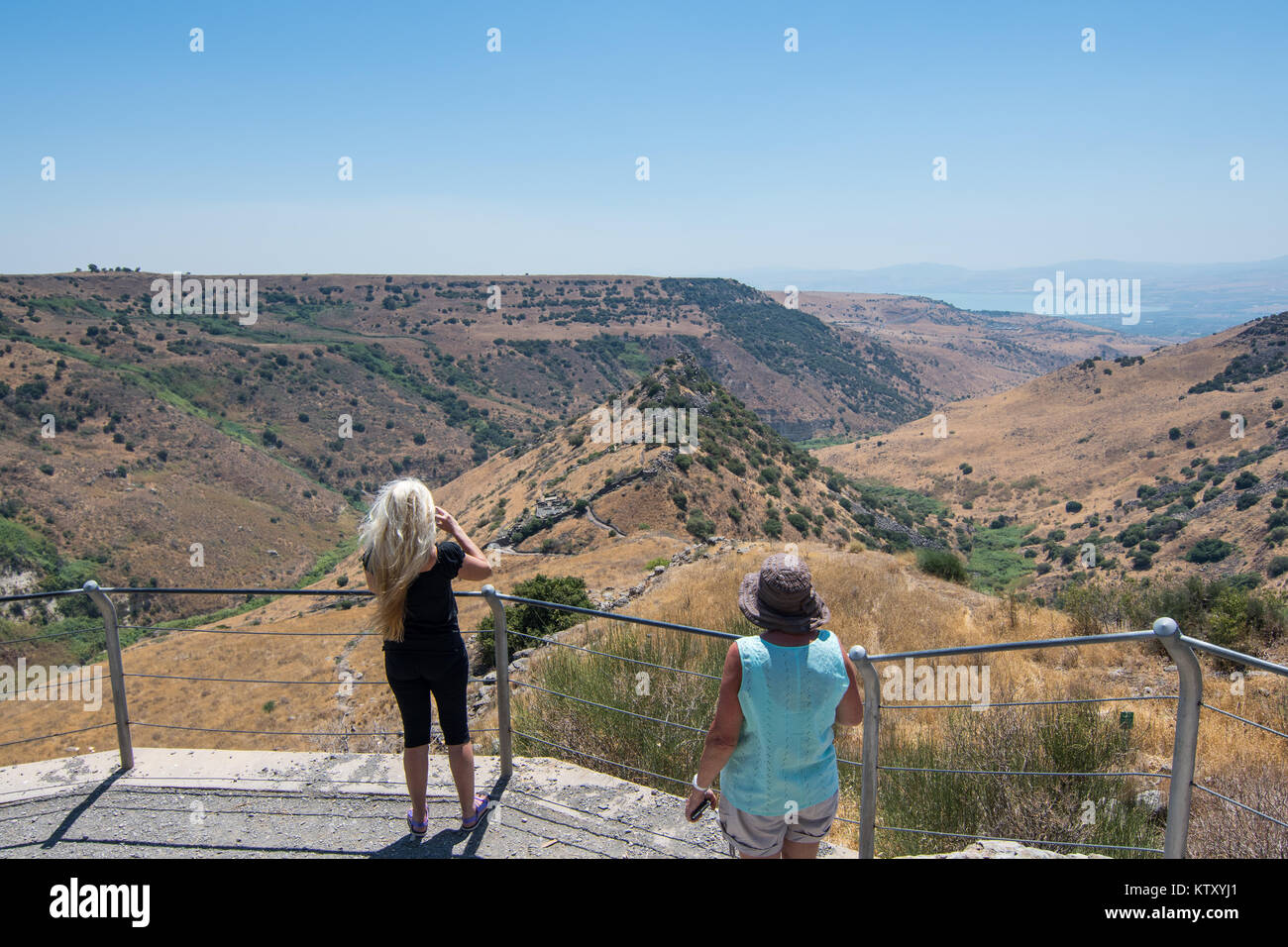 Two people taking pictures of the acropolis of ancient Gamla from the 'ancient trail' at the Gamla Nature Reserve at Northern Israel. Stock Photo