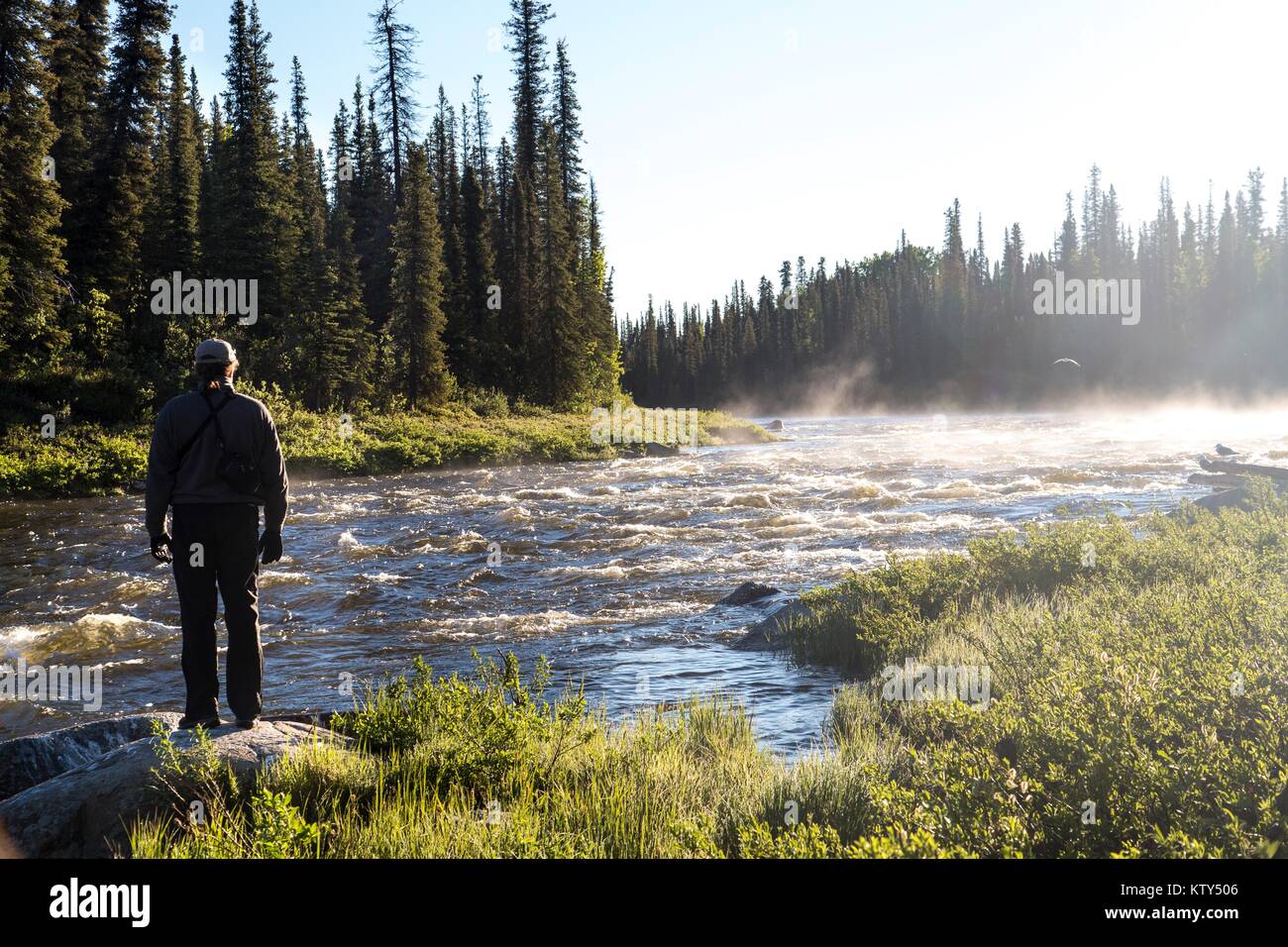 A tourist hikes along the Gulkana River June 22, 2014 near Fairbanks, Alaska. Stock Photo
