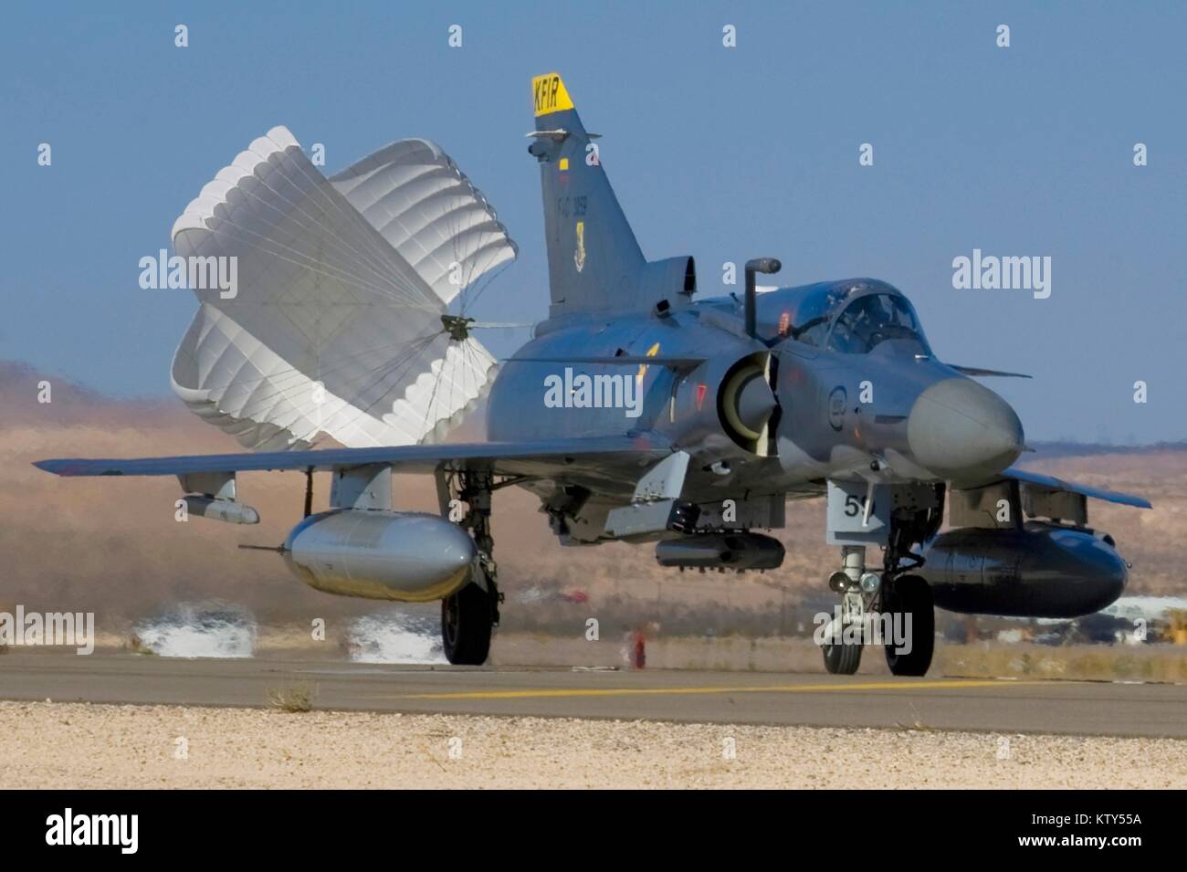 A drag chute deploys from a Colombian Air Force F-21 Kfir fighter jet aircraft as it lands at the Nellis Air Force Base during exercise Red Flag July 18, 2012 in Las Vegas, Nevada. Stock Photo