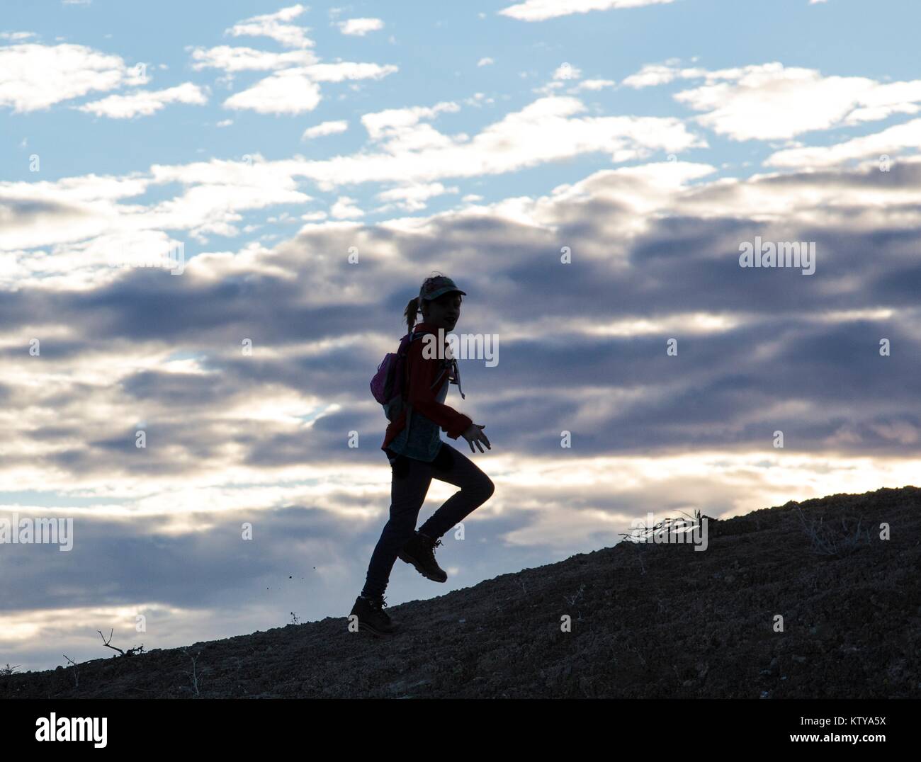 A tourist hikes up the Old Spanish National Historic Trail at sunset February 7, 2015 in Utah. Stock Photo