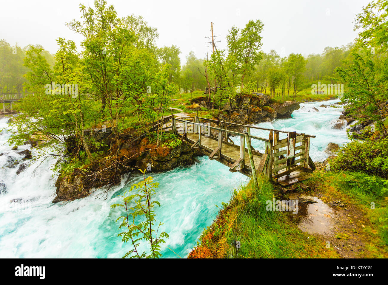 Travel, beauty in nature. Small bridge and waterfall torrential river along the Aurlandsfjellet mountains in Norway Sogn og Fjordane, foggy hazy summe Stock Photo