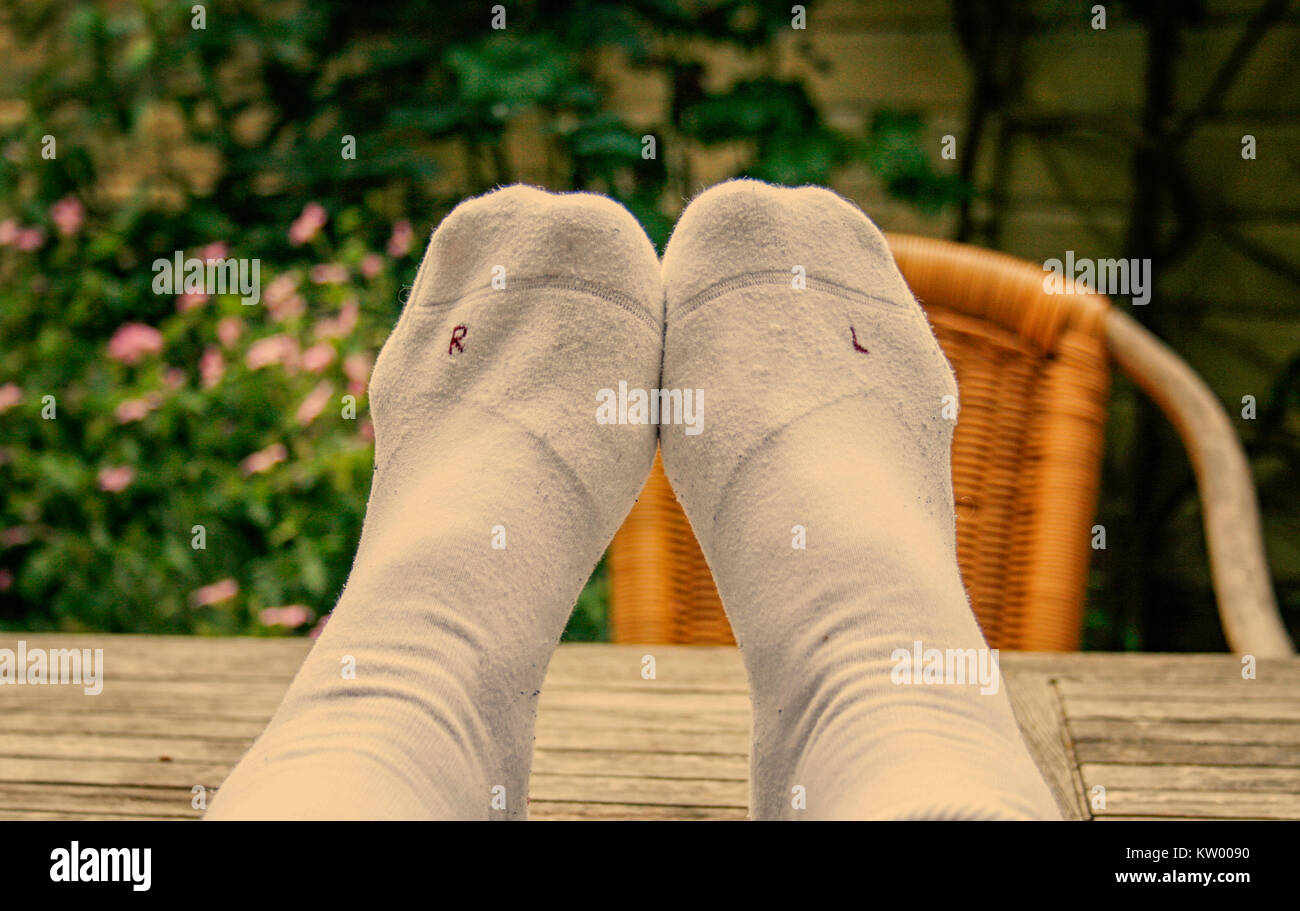 Wearing left sock on right foot and right sock on left foot. Stock Photo