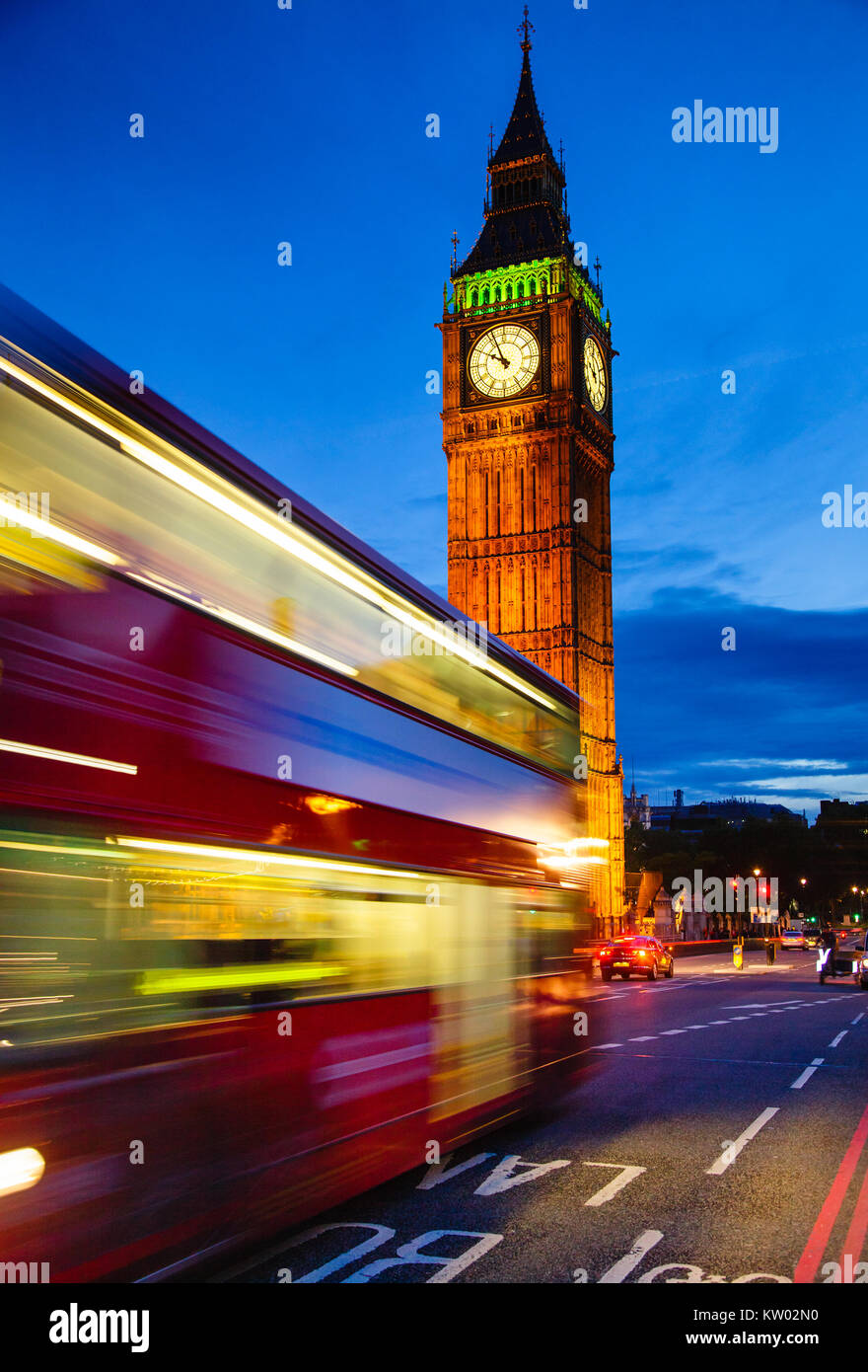 London night traffic scene with Doubledecker bus moves along the Westminster Bridge and  Elizabeth Tower or Big Ben in background Stock Photo