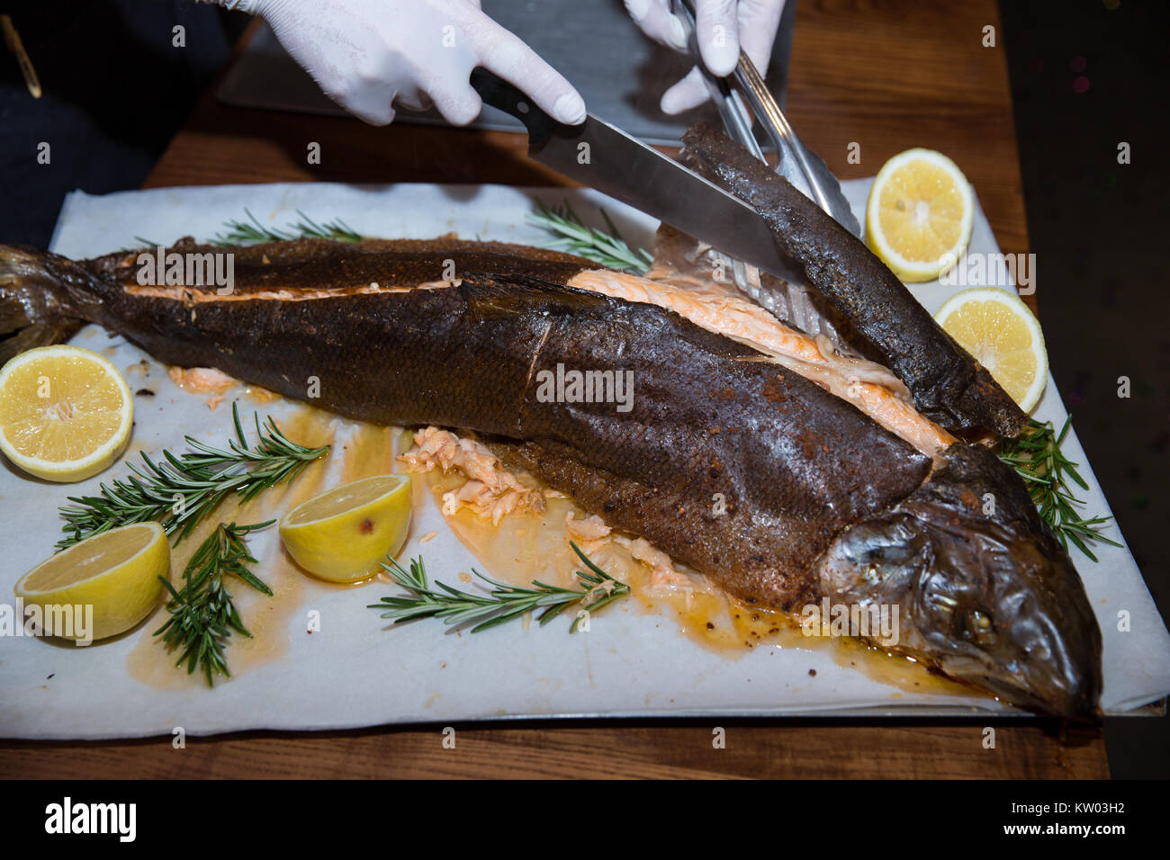 the waiter hands in white gloves cutting salmon fish in the restaurant  Stock Photo - Alamy
