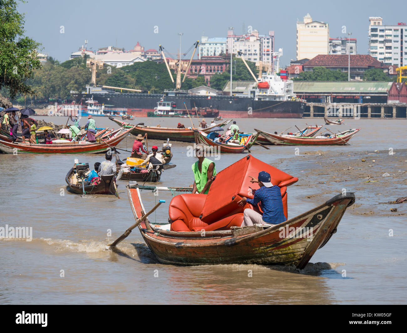 Local ferries and cargo vessels on Dala River where it enters Yangon River. Yangon Township visible on the opposite side of Yangon River. Stock Photo