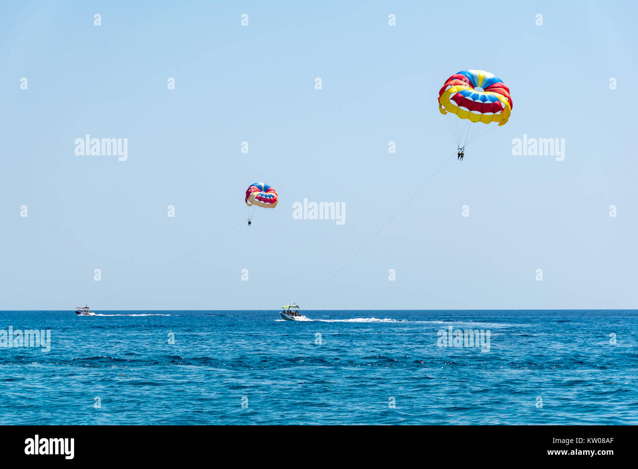 Two speed boats with people flying on parasailing parachute (RHODES, GREECE) Stock Photo