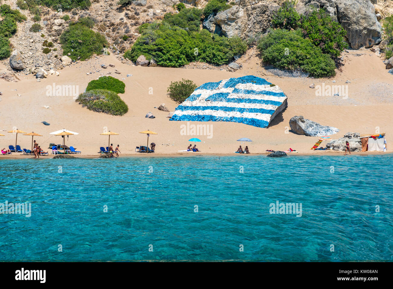 Tsambika beach with golden sand with big Greek flag painted on rock ...