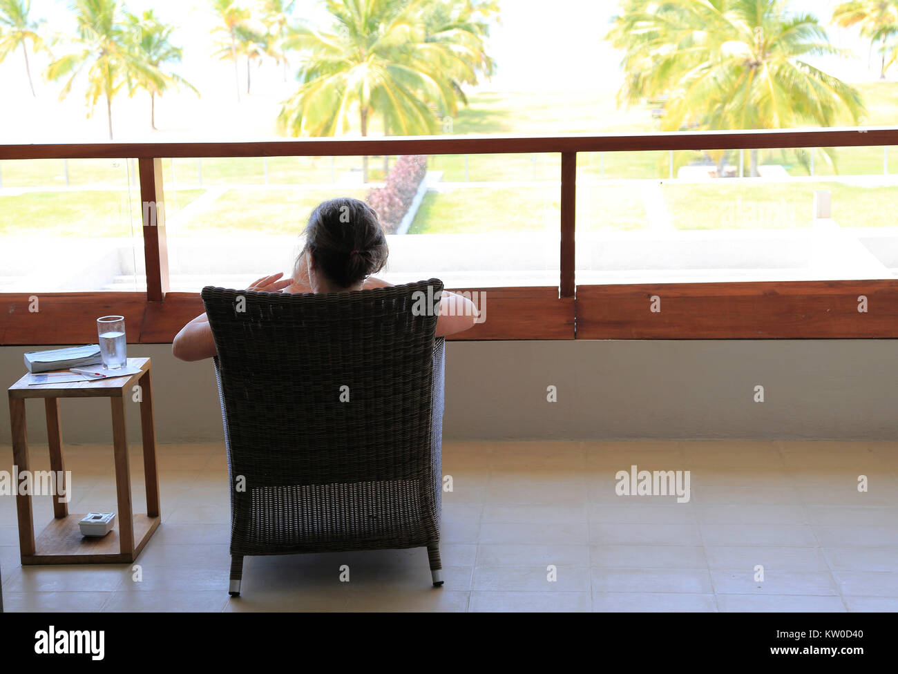 Woman relaxing on hotel balcony, Amaya Beach Resort hotel, Pasikudah bay, Eastern Province, Sri Lanka Stock Photo