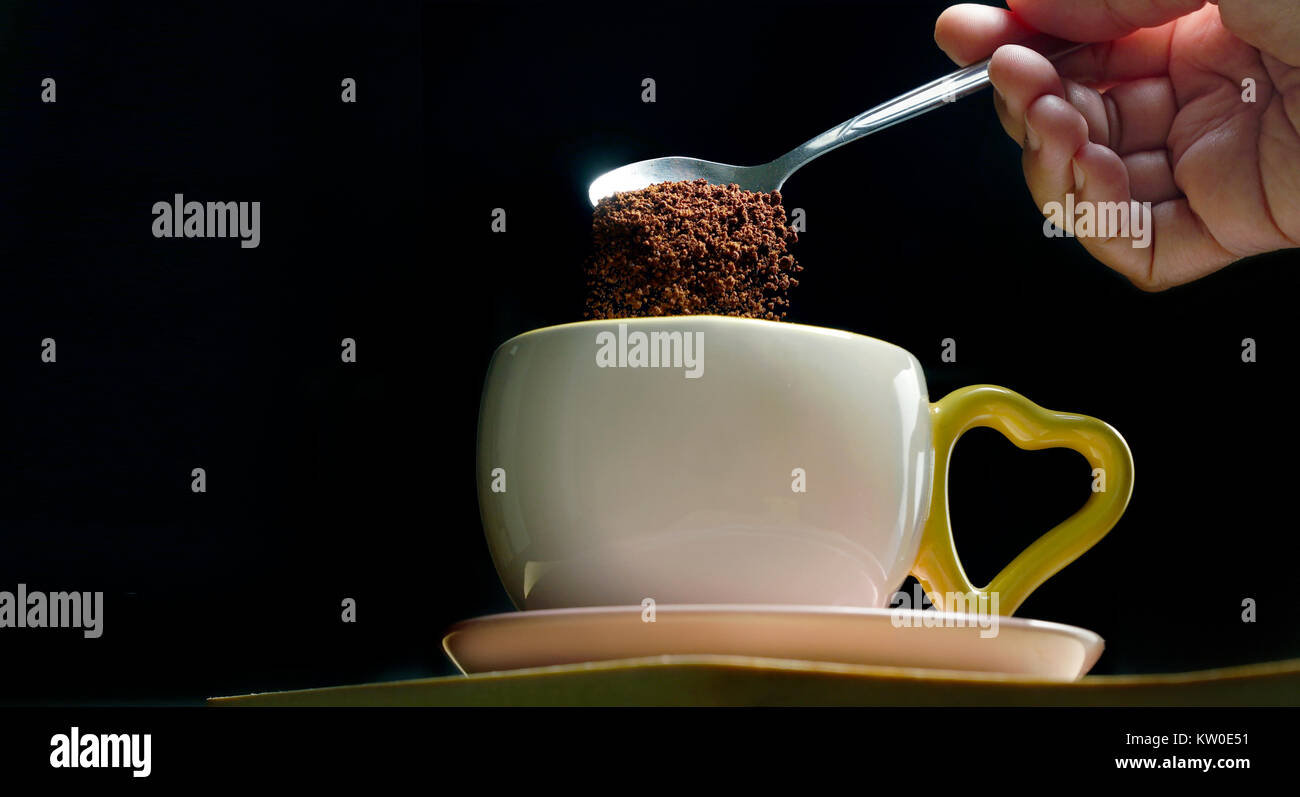 Pour a teaspoon of ground coffee into the cup. Stages of the process of making a cup of hot