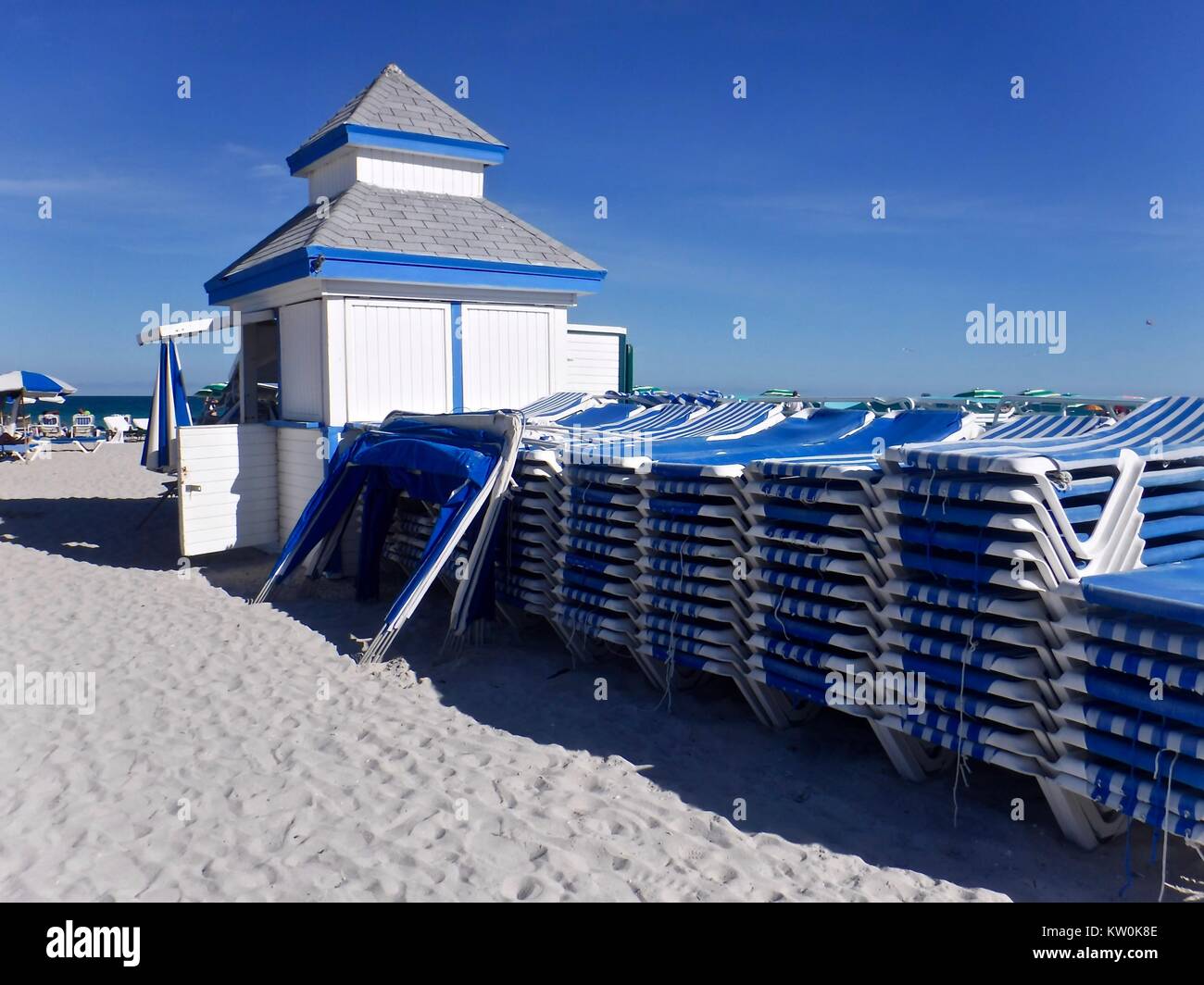 Blue and white Beach hut and piles of loungers Stock Photo