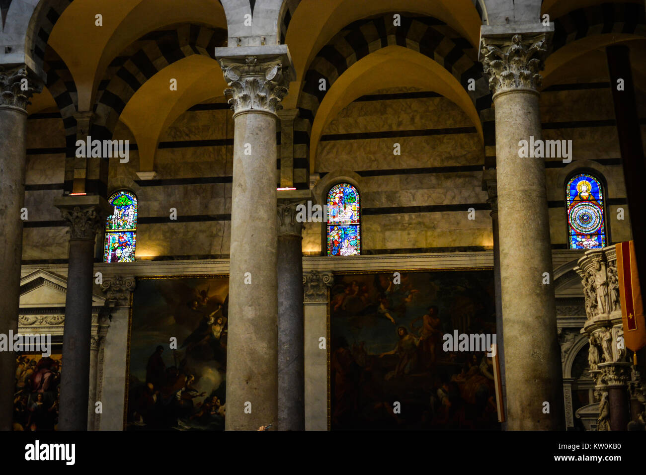 Beautiful stained glass windows and religious renaissance paintings in the interior of the Pisa Cathedral in Pisa Italy Stock Photo