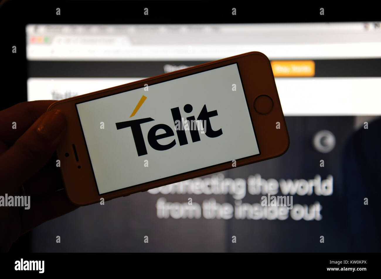 The Telit logo on a phone and their website on a computer Stock Photo