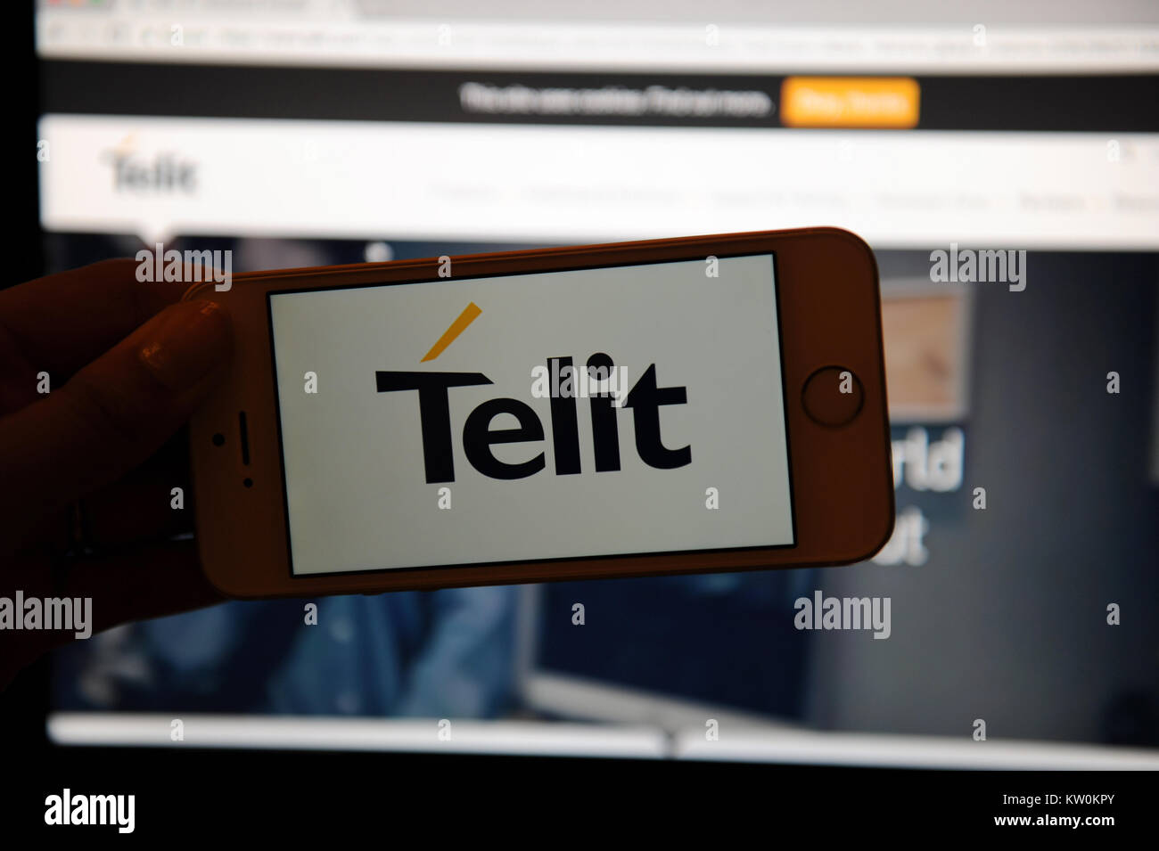 The Telit logo on a phone and their website on a computer Stock Photo