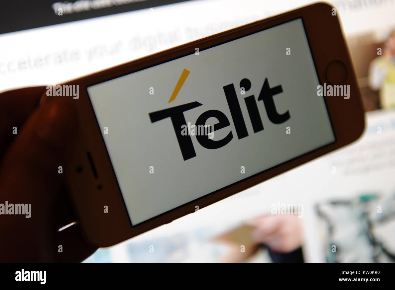 The Telit logo on a phone and their website on a computer Stock Photo