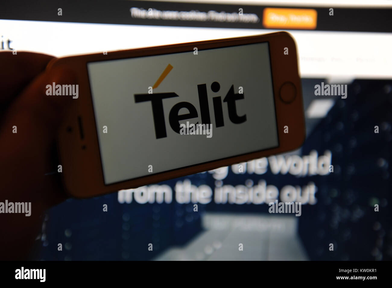 The Telit logo on a phone and their website on a computer Stock Photo