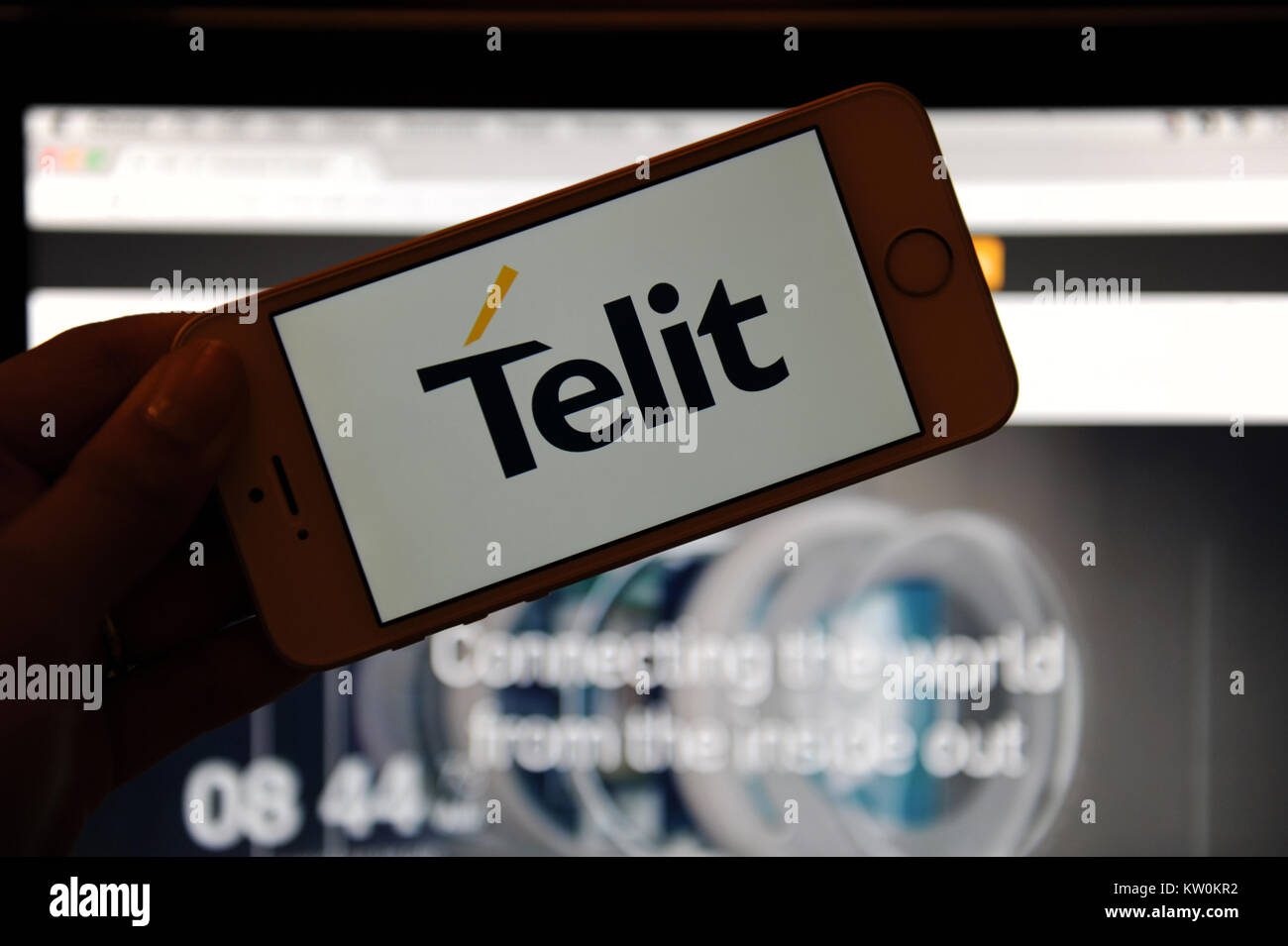 The Telit logo on a phone and their website on a computer Stock Photo