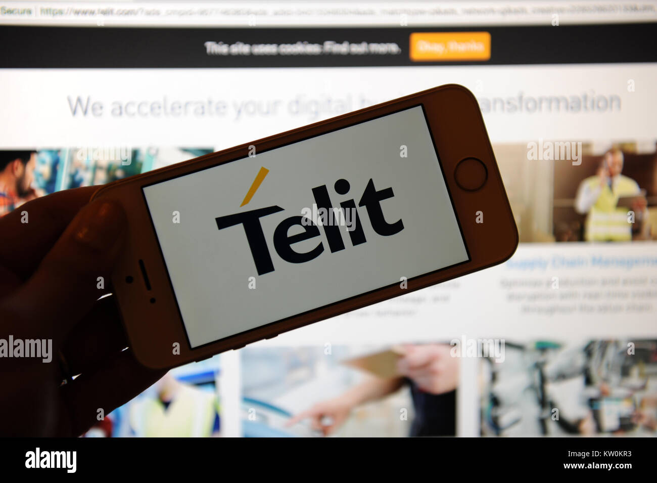 The Telit logo on a phone and their website on a computer Stock Photo
