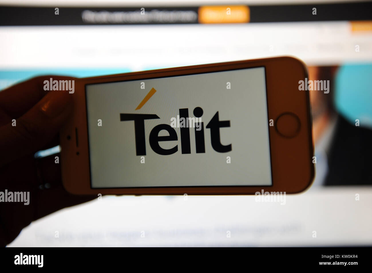 The Telit logo on a phone and their website on a computer Stock Photo