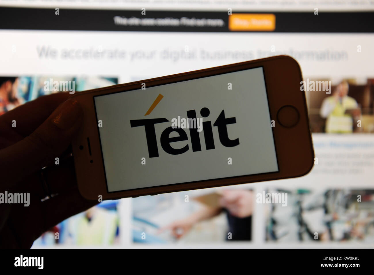 The Telit logo on a phone and their website on a computer Stock Photo