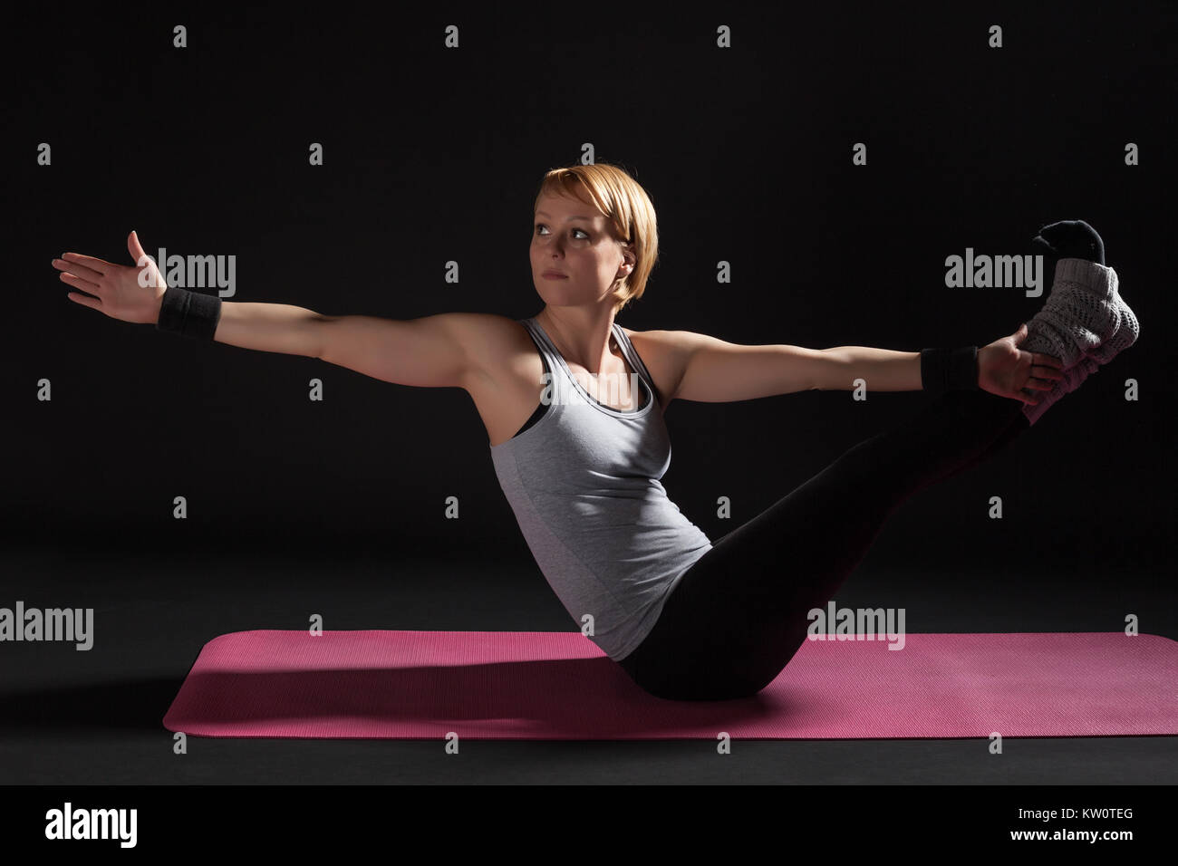 Young woman practicing yoga, Navasana / Boat position Stock Photo - Alamy