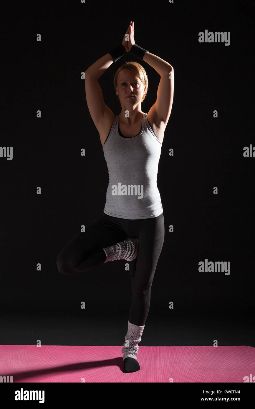 Young woman practicing yoga, Vrikshasana / Tree pose Stock Photo - Alamy