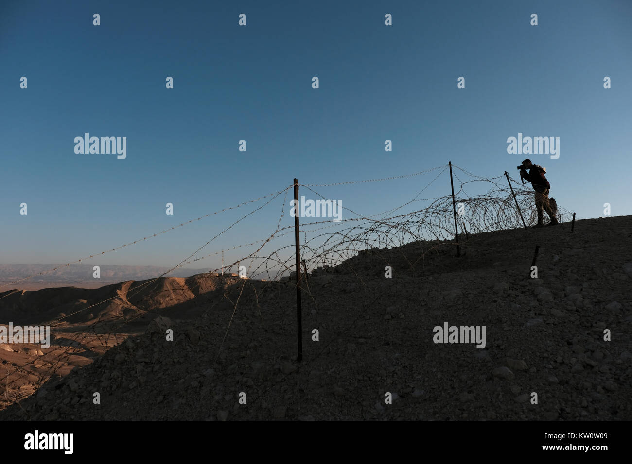 A young Israeli man taking photos from an Israeli military defense position on a strategic hill in the western of the Arabah valley known in Hebrew as Arava or Aravah which forms part of the border between Israel and Jordan. Stock Photo