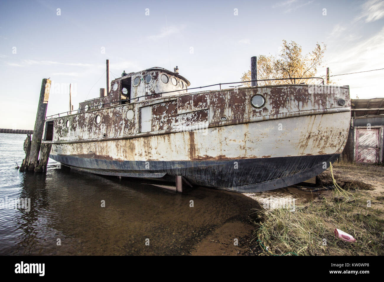 Weathered and worn commercial fishing boat beached on the shores of Lake Superior at the Whitefish Point Harbor in the Upper Peninsula of Michigan. Stock Photo