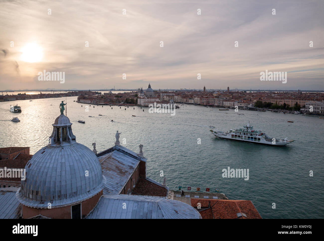 Evening view towards the Grand Canal, Venice, from the belltower of San Giorgio Maggiore showing the cupola of the church in the foreground and sunset Stock Photo