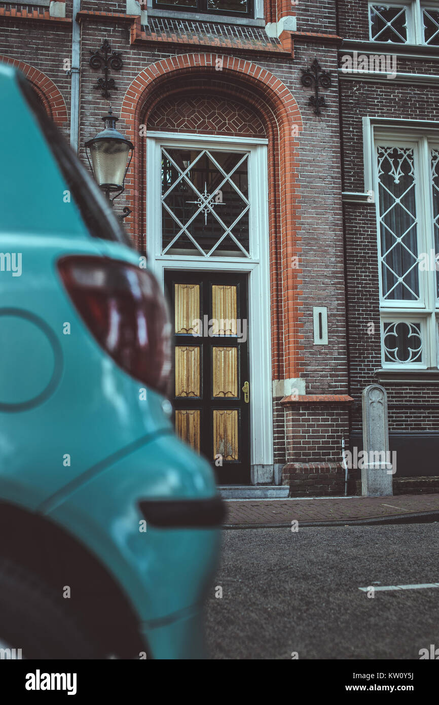 Part of blue car and antique door on background Stock Photo - Alamy