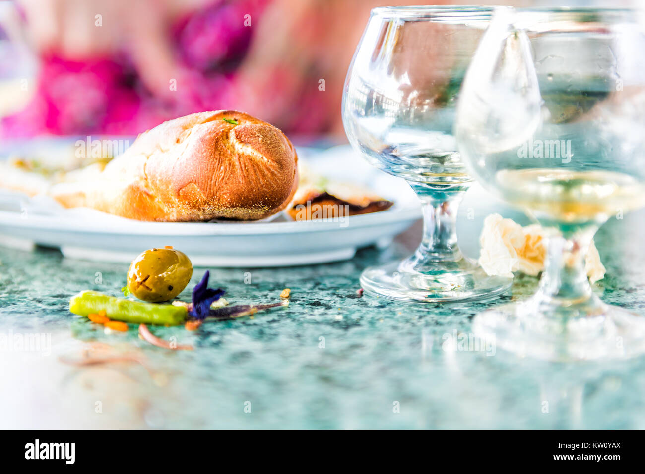 Closeup of leftovers in restaurant on table with small glass cognac whiskey rum glasses and messy dirty surface, bread Stock Photo
