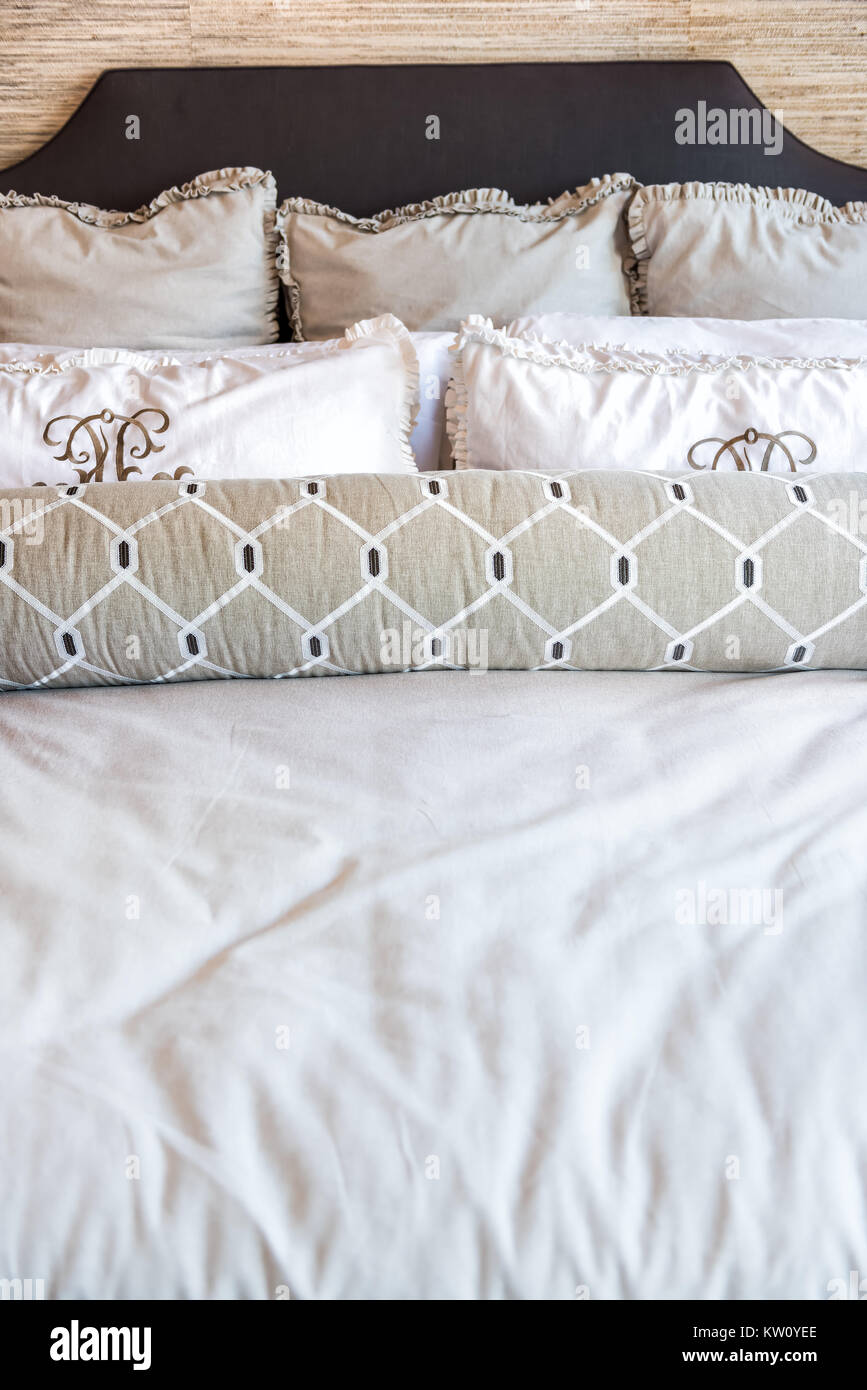 Closeup front view of new bed comforter with decorative pillows in bedroom in staging model home apartment or house Stock Photo