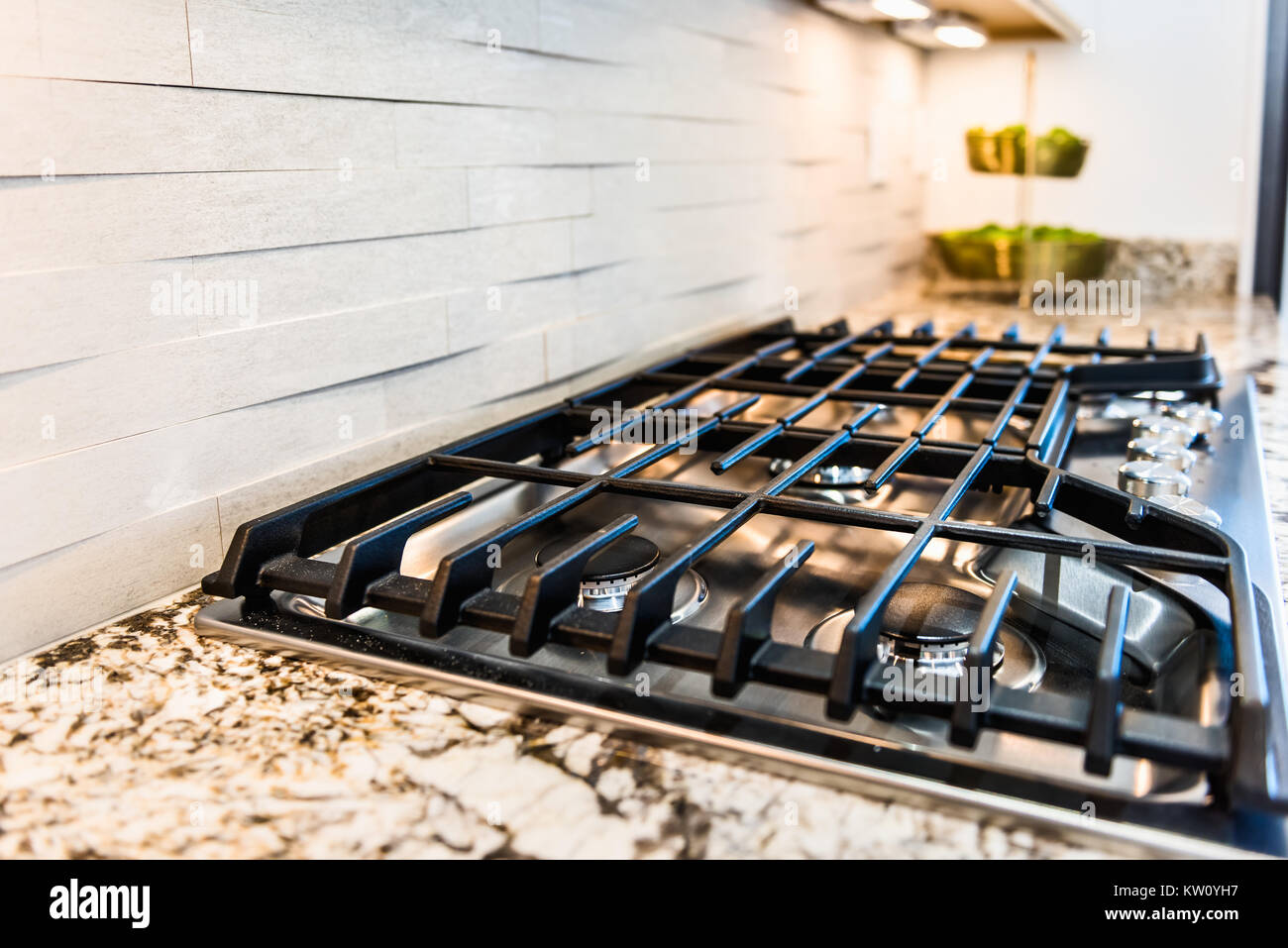 Macro closeup of modern luxury gas stove top with tiled backsplash