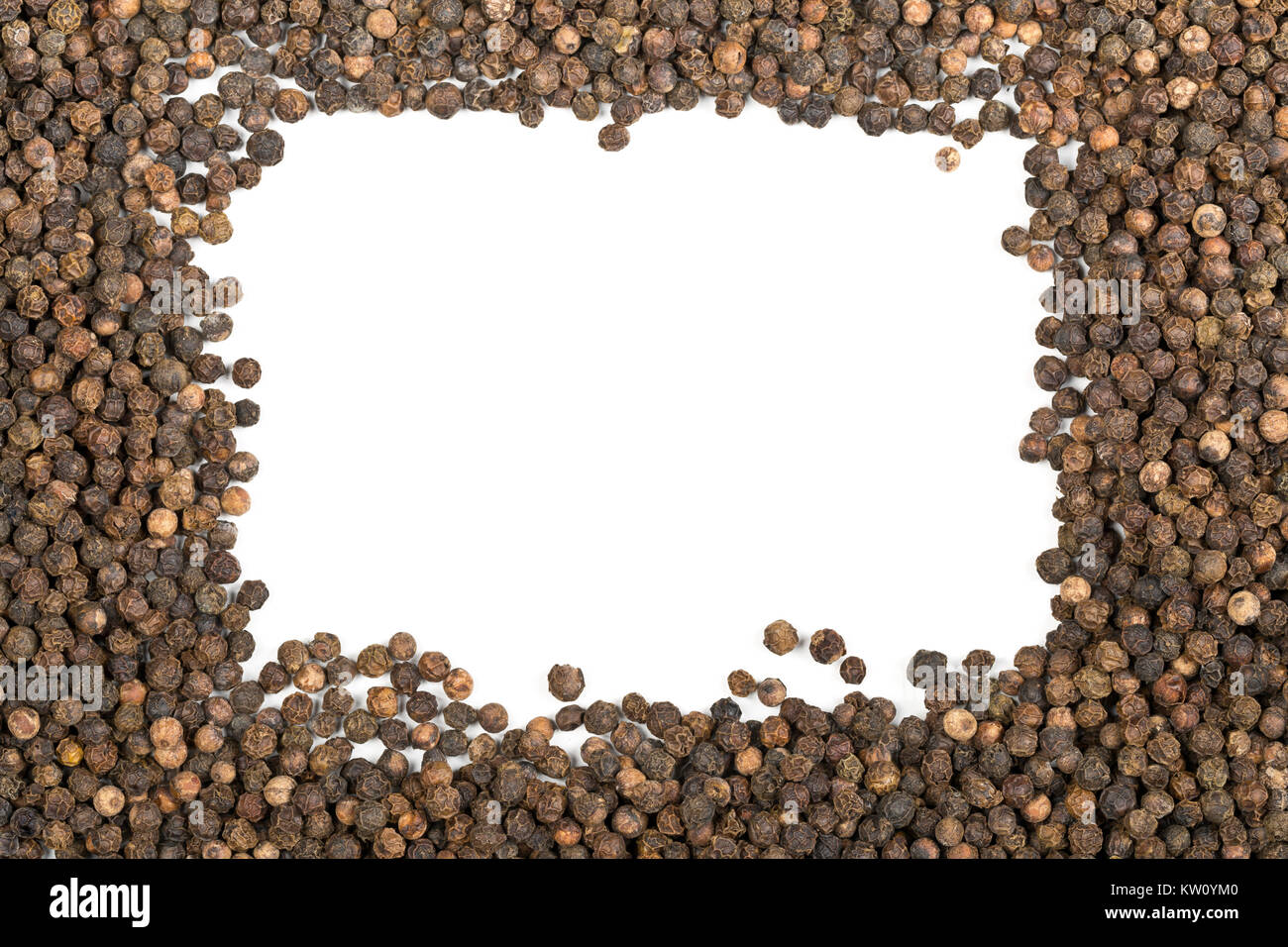 Frame of raw, natural, unprocessed black pepper peppercorns over white background Stock Photo