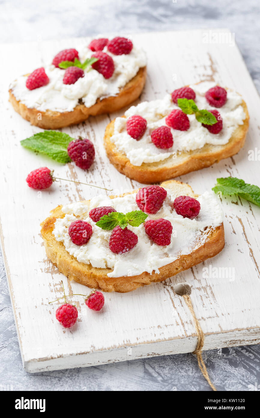 Three delicious toasts with Ricotta cheese and raspberries, decorated