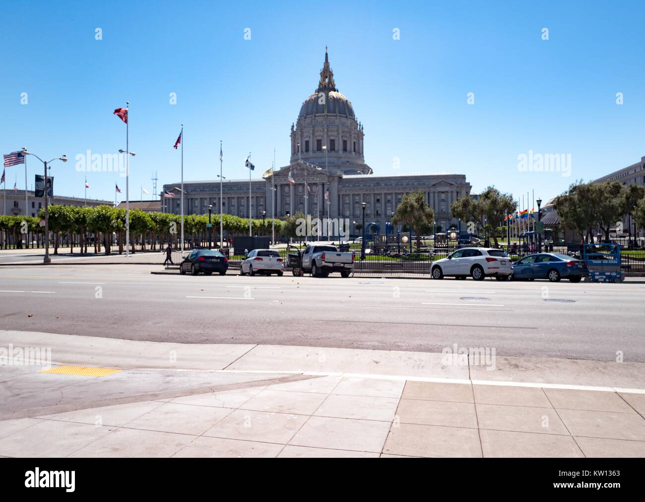San Francisco city hall, with gay pride flags visible at right flying at half mast to honor victims of the June 2016 mass shooting in Orlando, in the Civic Center neighborhood of San Francisco, California, 2016. Stock Photo