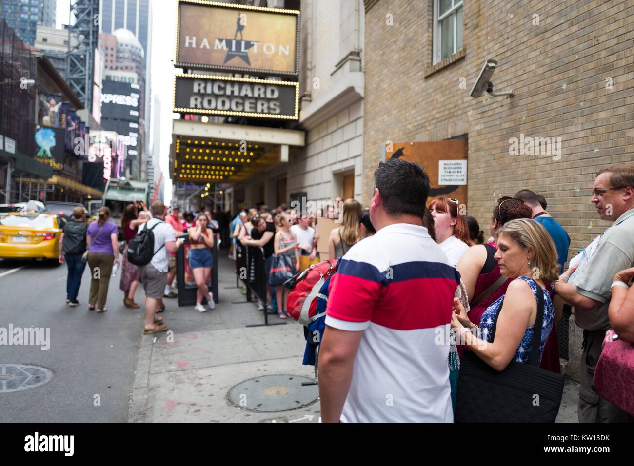 Before a performance of the Broadway musical Hamilton two days prior to creator Lin Manuel Miranda's departure from the show, fans gather at the stage door as musicians enter the theatre, New York City, New York, July 7, 2016. Stock Photo