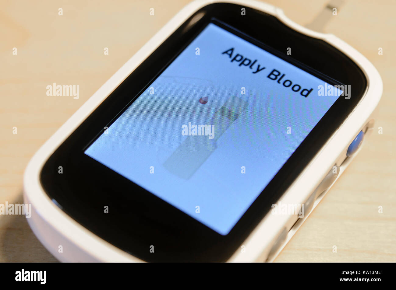 Blood glucose monitor asking the user to apply blood to the test strip Stock Photo