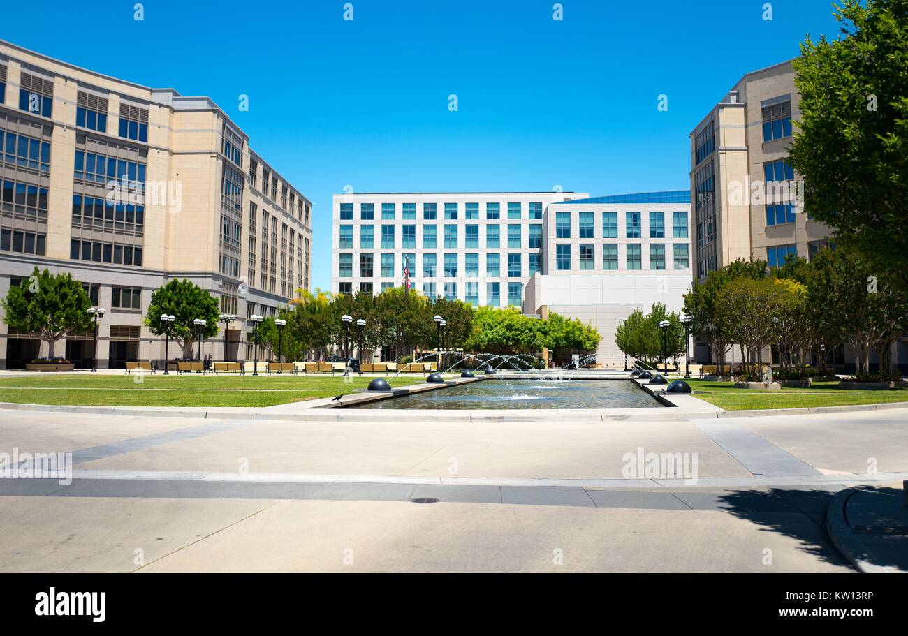 Fountains in the courtyard of the University Circle office complex, with top of the Four Seasons Hotel Silicon Valley visible, East Palo Alto, California, 2016. Stock Photo