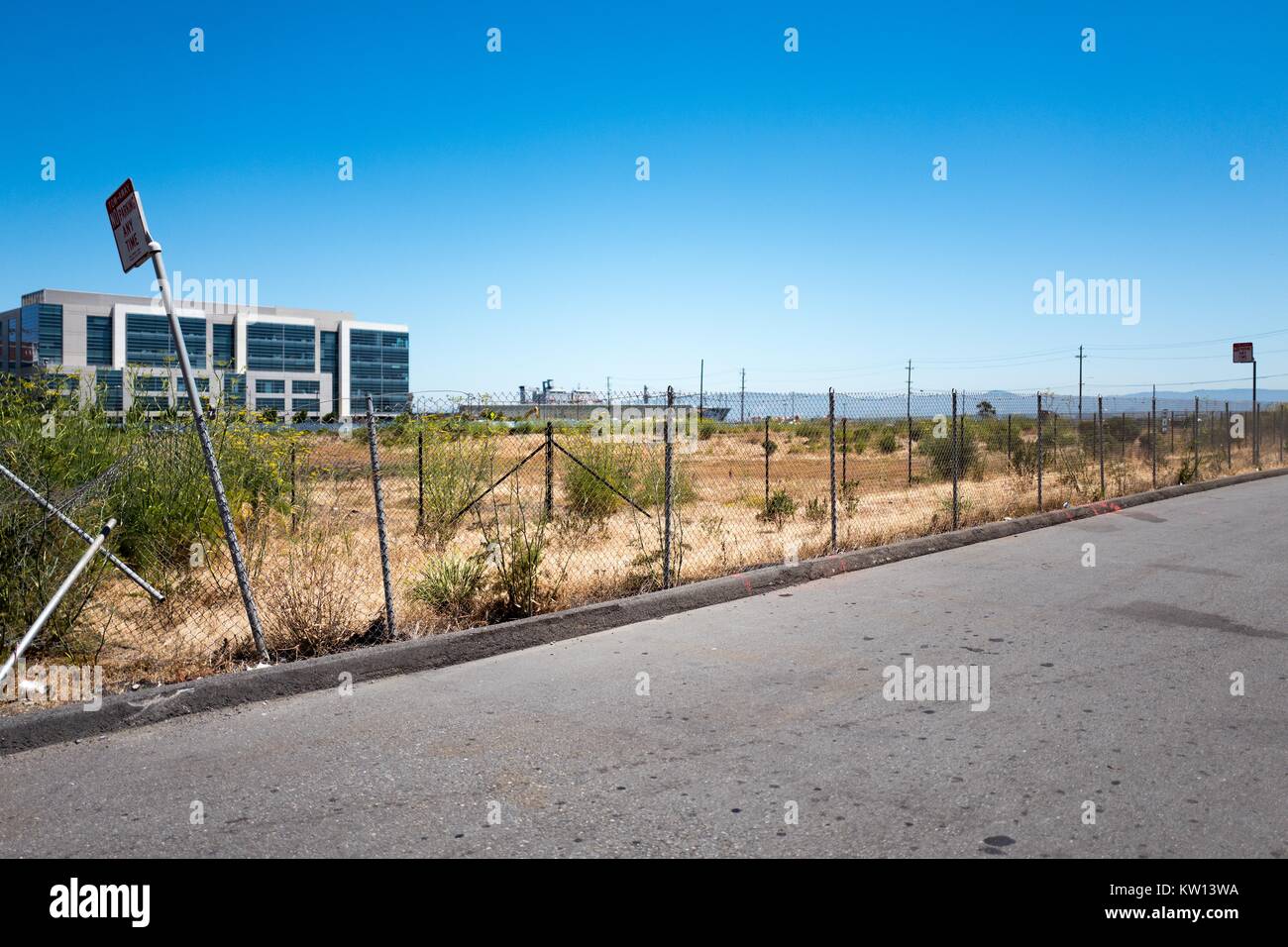 Vacant lot behind a chain link fence near the waterfront in the Mission Bay neighborhood of San Francisco, California, June, 2016. Stock Photo