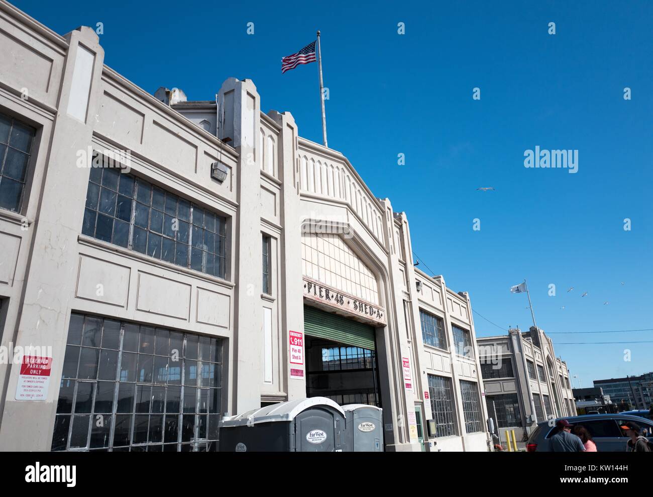 Pier 48, Shed A, a former storage shed at the Port of San Francisco, now used as a parking lot, on a sunny day, with an American Flag visible, San Francisco, California, 2016. Stock Photo