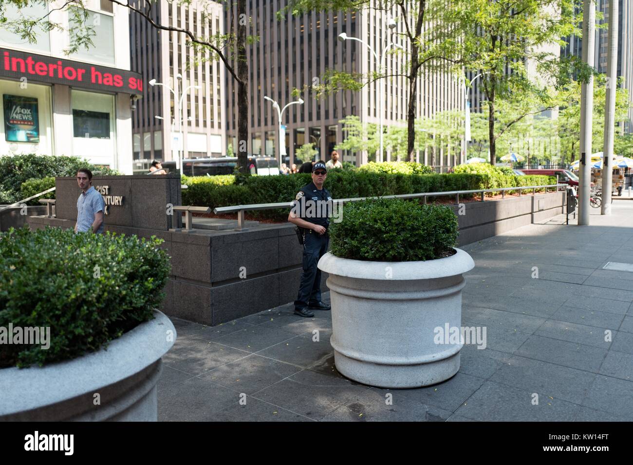 A counter-terrorism officer of the New York Police Department (NYPD) stand watchfully near the Manhattan headquarters of JP Morgan Chase, Manhattan, New York City, New York, July, 2016. Stock Photo