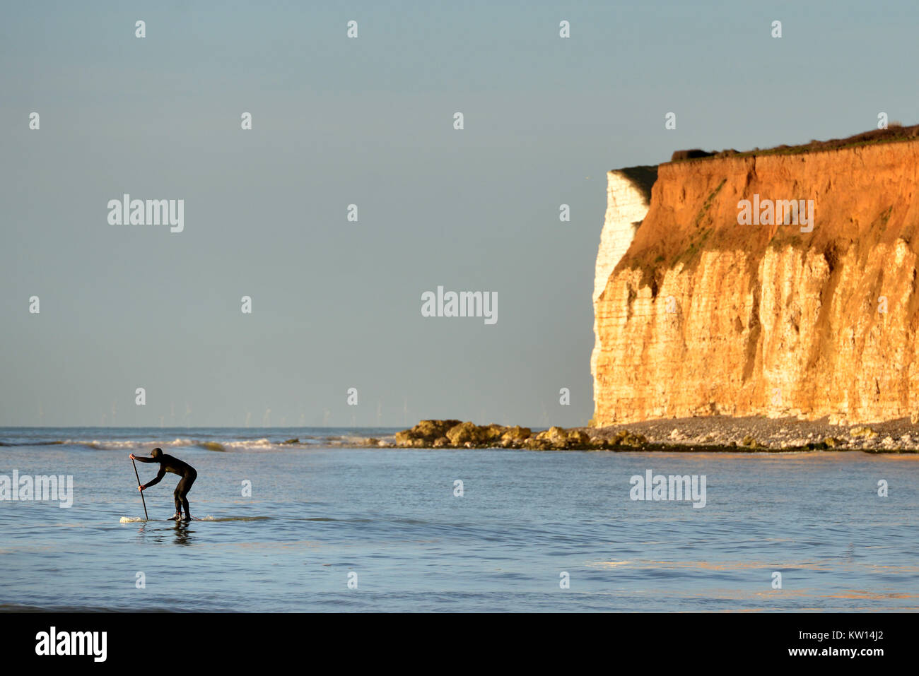 Paddleboarder near chalk cliffs in East Sussex Stock Photo Alamy